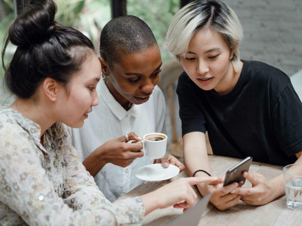 Three young adults looking at their social media